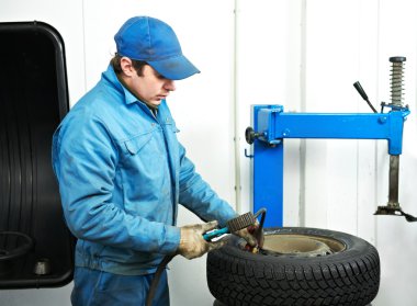 Machanic repairman at tyre fitting clipart