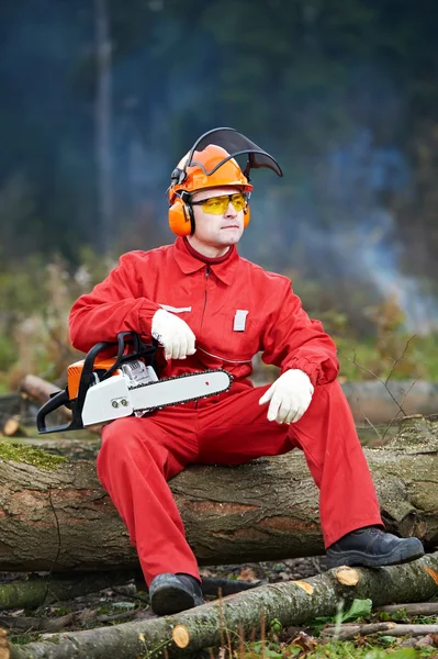 Lumberjack arbetare med motorsåg i skogen — Stockfoto