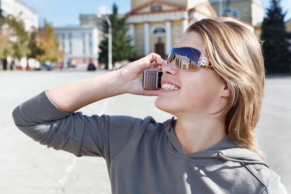 Young Russian beautiful girl on the mobile phone ringing outdoors. — Stock Photo, Image