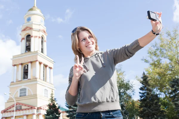 Joven hermosa mujer rusa fotografiándose a sí mismo contra la ciudad —  Fotos de Stock