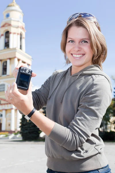 Young beautiful woman holding camera and smiling — Stock Photo, Image