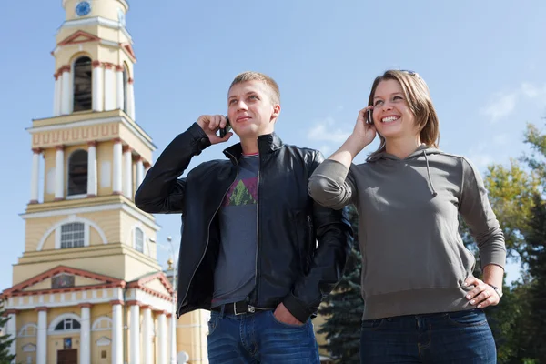 Jonge paar man en vrouw spreken op mobiele telefoon — Stockfoto