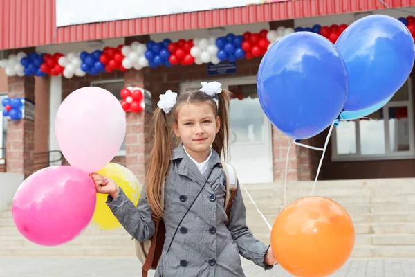 Little girl standing outdoor with color balloons — Stock Photo, Image