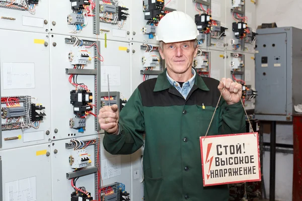 Electricista maduro trabajando en casco duro con cables y cables —  Fotos de Stock