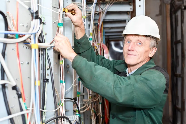 Starsze elektryk praca w twardy kapelusz z kabli i przewodów — Zdjęcie stockowe