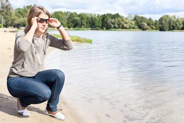 Young woman on the shore of river — Stock Photo, Image