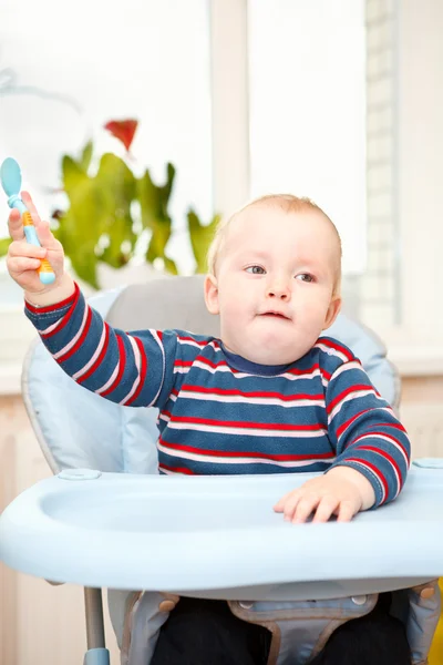 Pequeño niño sentado en la silla alta y agitando su cuchara —  Fotos de Stock