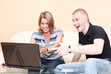 Two persons playing in games on laptop. clipart