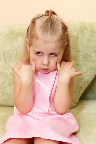 Küçük çocuk koltukta oturan pembe elbiseli bir kız — Stok fotoğraf