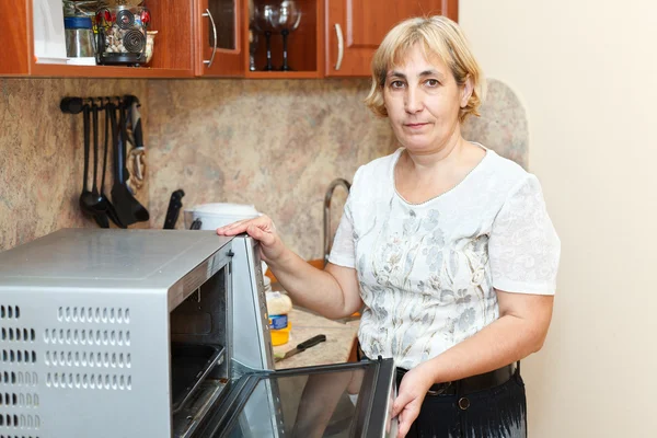 Зріла жінка стоїть на кухні — стокове фото