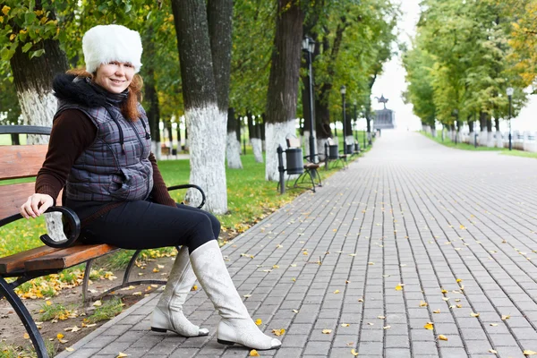 Belle jeune femme siégeant seul sur un banc de parc — Photo