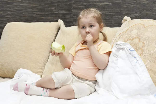 Маленький ребенок девочка сидит на диване в домашней комнате — стоковое фото