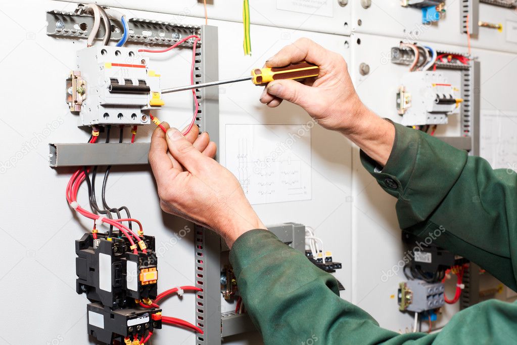 Electrician`s hands working with screwdriver