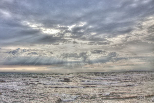 Solen strålar över moln över havet — Stockfoto