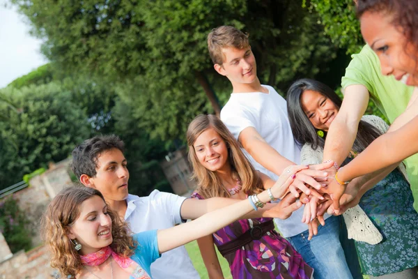 Gelukkig tiener groep met handen op stapel — Stockfoto
