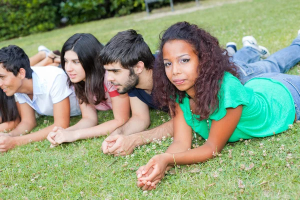 公園で地面に横たわっているティーンエイ ジャーのグループ — ストック写真