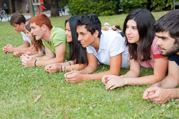 Grupo de adolescentes acostados en el suelo en el parque — Foto de Stock