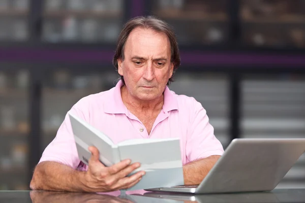 Starší muž s počítačem v kanceláři — Stock fotografie