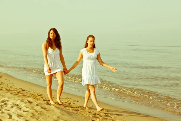 Kvinnliga vänner gå tillsammans i havet — Stockfoto