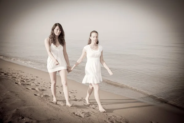 Amigos do sexo feminino caminhando juntos no litoral — Fotografia de Stock