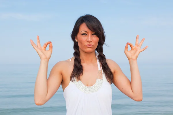 Hermosa joven haciendo ejercicios de yoga en la playa —  Fotos de Stock