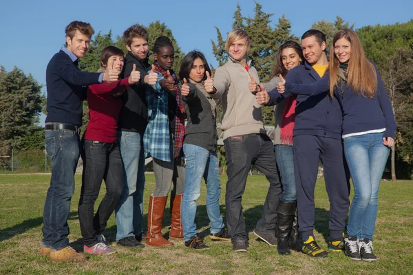Счастливые студенты колледжа с большими пальцами — стоковое фото