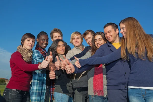 Glada studenter med tummen upp — Stockfoto