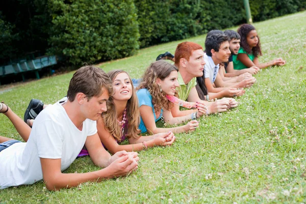 Gruppe Jugendlicher liegt im Park auf dem Boden — Stockfoto