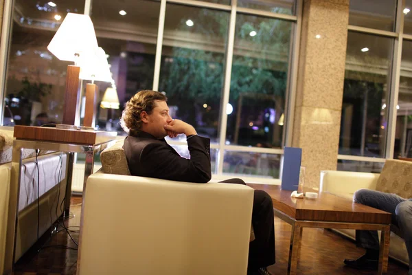 Man relaxing in hotel lobby — Stock Photo, Image