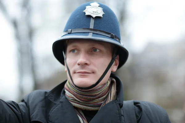 Ernster Mann mit britischem Polizeihut — Stockfoto