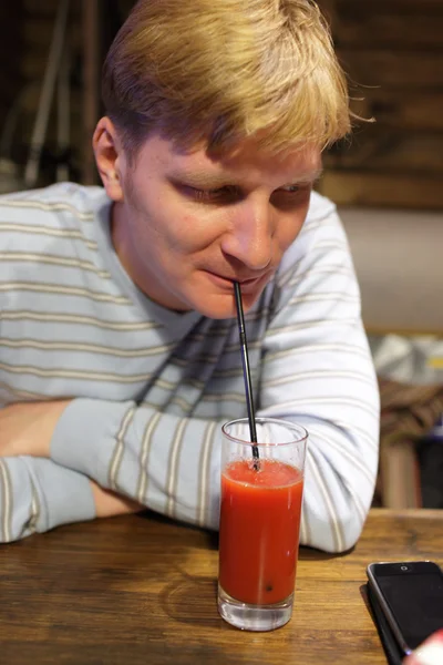Человек пьет томатный сок — стоковое фото