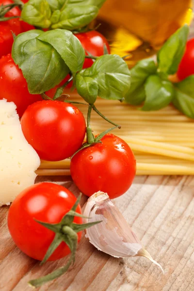 Pasta, olivolja och tomater på trä bakgrund — Stockfoto