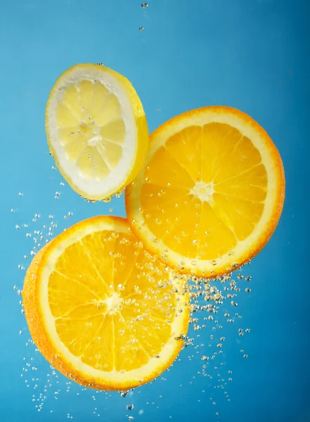 stock image Fresh orange dropped into water