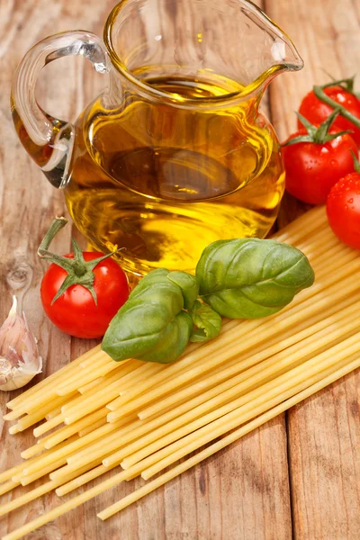 Pâtes, huile d'olive et tomates sur fond de bois — Photo