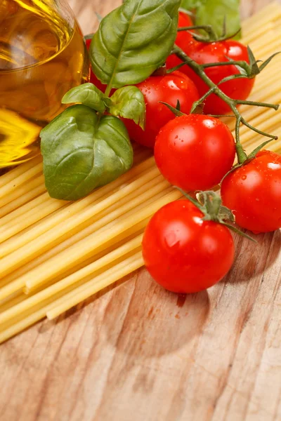 Massa, azeite e tomate sobre o fundo de madeira — Fotografia de Stock