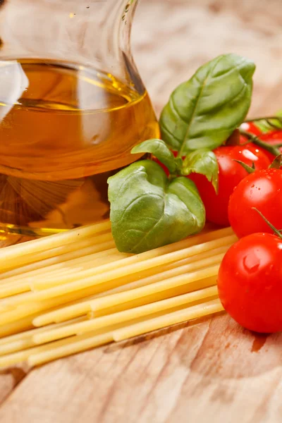 Těstoviny, olivový olej a rajčaty na dřevo pozadí — Stock fotografie