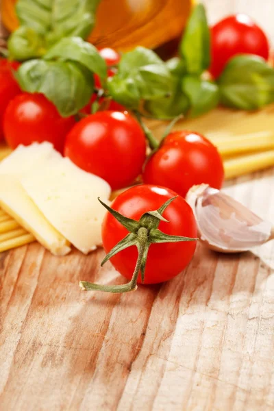 Makarna, zeytinyağı ve ahşap arka plan domates — Stok fotoğraf