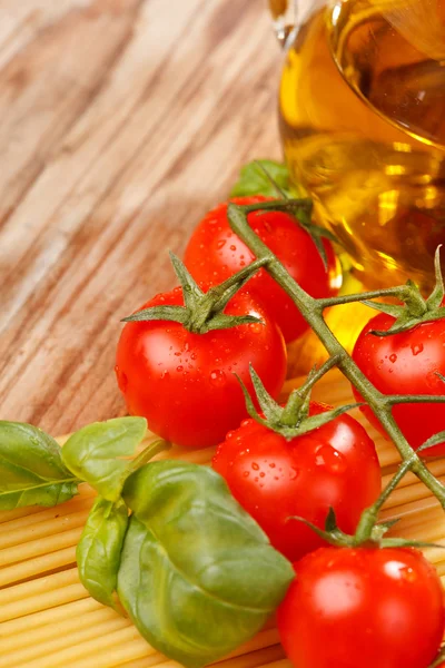 Pasta, olio d'oliva e pomodori sullo sfondo di legno — Foto Stock