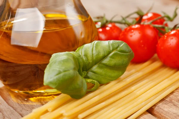 意大利面、 橄榄油和木材的背景上西红柿 — 图库照片