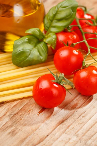 Nudeln, Olivenöl und Tomaten auf dem Holz Hintergrund — Stockfoto