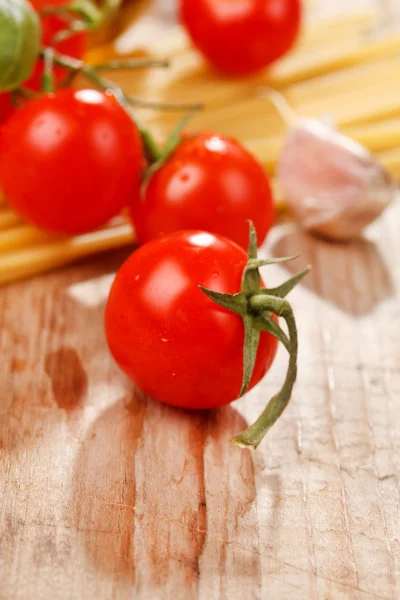 Pasta, olive oil and tomatoes on the wood background — Stock Photo, Image