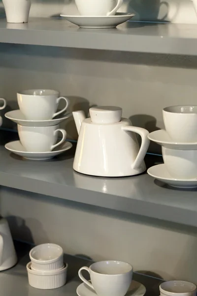 Білі чашки на полиці — стокове фото
