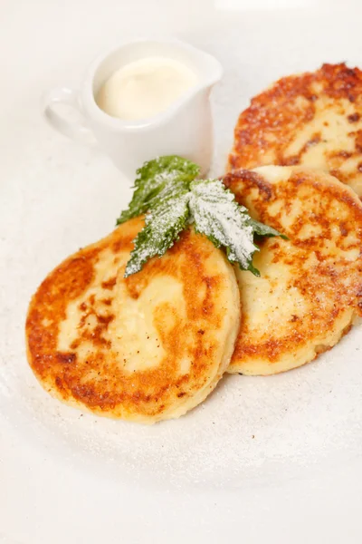 Cheese pancakes with sour cream — Stock Photo, Image