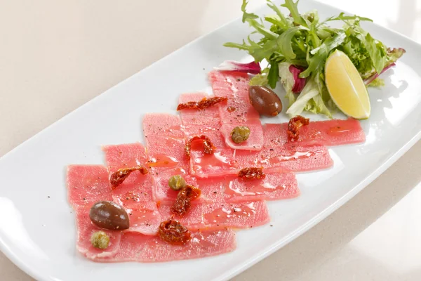 Fish Carpaccio with olives ana salad — Stock Photo, Image