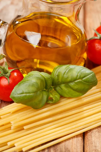 Pâtes, huile d'olive et tomates sur fond de bois — Photo