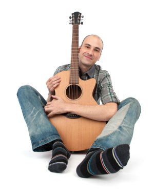 adam bir gitarla oturur