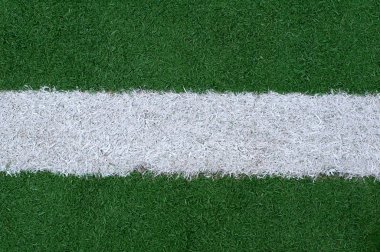 Sports lines painted on a green grassy playing field clipart