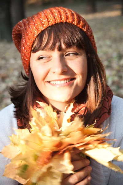Vrouw met oranje Herfstbladeren — Stockfoto