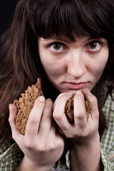 Arme bedelaar vrouw met een stukje brood — Stockfoto