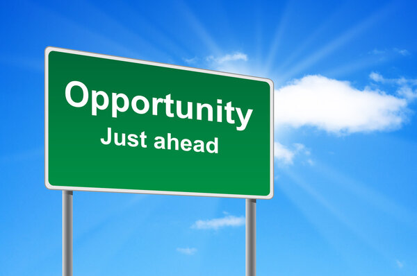 Opportunity road sign on background clouds and sunburst.